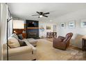 Cozy living room with a fireplace, ceiling fan, and comfortable seating at 103 W Sunset Dr, Locust, NC 28097