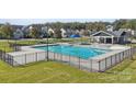 Large community pool with multiple lap lanes, surrounded by a black fence and lush green lawn at 108 Goorawing Ln, Mooresville, NC 28115
