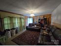 Inviting living room with wood paneling, comfortable leather seating, and a classic ceiling light fixture at 116 E Graves St, Candor, NC 27229