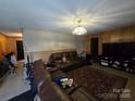 Cozy living room with wood paneling, a plush leather sofa, and a patterned rug at 116 E Graves St, Candor, NC 27229
