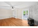 Hardwood floored living room showcasing a brick fireplace, built-in shelving, and a ceiling fan at 119 Oak Ave, Shelby, NC 28152