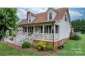 Charming home featuring a welcoming front porch, manicured landscaping, and classic architectural details at 139 Pleasant Garden Dr, Taylorsville, NC 28681