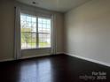 Bright bedroom with large window and dark hardwood floors, perfect for relaxation at 147 Dubois Dr, Mooresville, NC 28115