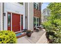 Inviting front entrance with a red door, brick pathway, and decorative landscaping at 16018 Hollingbourne Rd, Huntersville, NC 28078