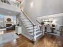 Elegant foyer with staircase, wood floors, and view into the living and dining rooms at 16308 Woolwine Rd, Charlotte, NC 28278
