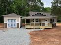 Charming single-Gathering home featuring a covered porch, neutral siding, and a detached garage in a wooded neighborhood at 1987 Robert Rufty Ln, Catawba, NC 28609