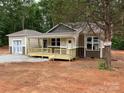 Charming single-Gathering home featuring a covered porch, neutral siding, and a detached garage in a wooded neighborhood at 1987 Robert Rufty Ln, Catawba, NC 28609