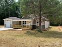 Inviting home with a covered porch and a detached garage, framed by a mature tree and fresh landscaping at 1987 Robert Rufty Ln, Catawba, NC 28609