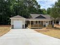 Welcoming home with a covered porch and a detached garage, complemented by a newly paved driveway at 1987 Robert Rufty Ln, Catawba, NC 28609