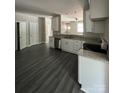 Open-concept kitchen featuring white cabinets, gray counters, stainless steel appliances, and durable luxury vinyl plank flooring at 1987 Robert Rufty Ln, Catawba, NC 28609
