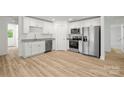 Bright kitchen with white cabinets, stainless steel appliances, and a granite countertop at 212 N Correll St, Landis, NC 28025