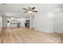 Open concept living room with modern fan, light hardwood floors, and bright white paint at 212 N Correll St, Landis, NC 28025