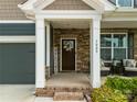 Inviting front porch with stone accents and a 'welcome' sign, offering a cozy seating area at 3009 Lydney Cir, Waxhaw, NC 28173