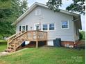 Exterior view of the back of the house featuring a wooden deck with stairs and a well-maintained lawn at 329 Highland Dr, Lincolnton, NC 28092
