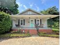 Welcoming front porch with light gray siding, a swing, and a vibrant teal front door adorned with a 'Welcome' sign at 329 Highland Dr, Lincolnton, NC 28092