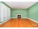Bright living room featuring a cozy fireplace and hardwood floors at 3526 Craig Ave, Charlotte, NC 28211