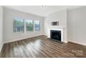 Cozy living room with a fireplace, large windows, and wood-look flooring perfect for modern living at 4026 Honey Locust Dr, Charlotte, NC 28215