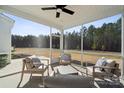 Relaxing screened-in patio with comfortable seating and views of the wooded backyard at 423 Balboa St, Matthews, NC 28104