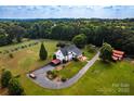 Aerial view shows a beautiful home with a long driveway and lots of trees in a country setting at 5258 E Bandys Cross Rd, Catawba, NC 28609
