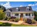 Charming home boasts a welcoming front porch, beautiful landscaping, and a stone and vinyl facade at 5258 E Bandys Cross Rd, Catawba, NC 28609