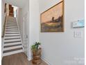 Bright foyer featuring hardwood floors and stairs, a stylish table with plant, and a landscape art piece at 5508 Swaling St, Charlotte, NC 28217