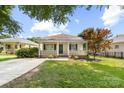 Adorable single-story home exhibits a delightful front porch, lush landscaping, and a well-maintained lawn at 613 Church St, Belmont, NC 28012