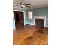 Inviting living room with hardwood floors, a ceiling fan, and a classic brick fireplace at 8000 Chapman St, Charlotte, NC 28216