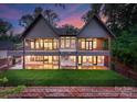 Rear exterior with balconies, large windows, and a spacious backyard, perfect for outdoor relaxation and entertainment at 8066 Edgewater Dr # 103, Norwood, NC 28128