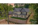 Rear exterior showcasing a multi-level deck with black railings, and large windows overlooking the property at 8066 Edgewater Dr # 103, Norwood, NC 28128