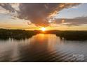 Scenic lake view with a vibrant sunset, highlighting the property's prime waterfront location and tranquil setting at 8066 Edgewater Dr # 103, Norwood, NC 28128