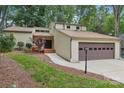 Attractive exterior of a home with a two-car garage, surrounded by mature trees and greenery at 8117 Rising Meadow Rd, Charlotte, NC 28277