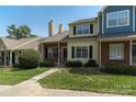 Charming townhouse with brick facade, black shutters, and a well-kept lawn on a sunny day at 9006 Four Mile Creek Rd, Charlotte, NC 28277