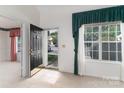 Bright foyer featuring tile flooring, a window with decorative curtains, and an open view into other rooms at 9006 Four Mile Creek Rd, Charlotte, NC 28277