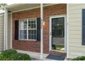 Inviting entrance with brick accents, decorative door, and a well-lit porch, enhancing curb appeal at 9006 Four Mile Creek Rd, Charlotte, NC 28277