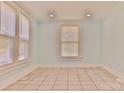 Bright room featuring tile flooring, light blue walls, and two windows at 102 Lake Dr, Hickory, NC 28601