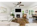 Cozy living room features a ceiling fan, brick fireplace, and ample natural light at 1041 Brawley School Rd, Mooresville, NC 28117