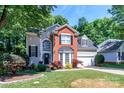 Lovely two-story home featuring brick accents, a garage, and lush, mature landscaping at 10419 Chelsea Bay Dr, Charlotte, NC 28278