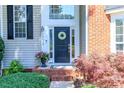 Welcoming front entrance with a wreath on the door and colorful landscaping at 10419 Chelsea Bay Dr, Charlotte, NC 28278