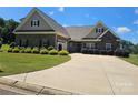 Beautiful home with stone and brick facade, an expansive driveway, and a manicured lawn with lovely bushes at 1108 Tarram Ct # 12, Lancaster, SC 29720