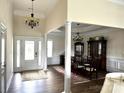Elegant foyer with hardwood floors, chandelier, and view to the dining room with wainscoting and pillars at 1108 Tarram Ct # 12, Lancaster, SC 29720