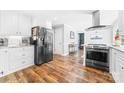 Modern kitchen boasts stainless steel appliances, white cabinetry, granite countertops, and wood-look flooring at 120 Labans Ln, Lincolnton, NC 28092