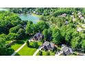 Panoramic aerial view of the upscale home with lake access, lush trees, and manicured lawns at 132 Parkside Ln, Mooresville, NC 28117