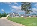 An exterior view of a suburban home on a lush green lawn with a long driveway and a mature tree at 1327 Springlake Rd, York, SC 29745