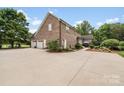 Expansive driveway, three-car garage, and outdoor living space with a pergola at 1533 Ohara Plantation Ct, Dallas, NC 28034