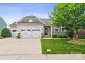 Charming single-Gathering home featuring a stone facade, two-car garage, and well-maintained landscaping at 2112 Balting Glass Dr, Indian Trail, NC 28079