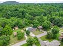 Expansive aerial view featuring a home with a pool, nestled in lush greenery, with a mountain backdrop at 2666 Hill Ln, Gastonia, NC 28054