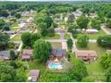 Beautiful aerial view of a neighborhood featuring a home with a private backyard pool surrounded by mature trees at 2666 Hill Ln, Gastonia, NC 28054