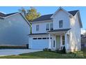 Charming two-story home with vinyl siding, a welcoming front porch, and an attached garage at 320 Lawrence Gray Rd, Charlotte, NC 28262