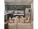 Modern eat-in kitchen with stainless steel appliances, stylish green cabinets, and quartz countertops at 320 Lawrence Gray Rd, Charlotte, NC 28262