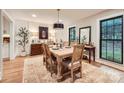 A formal dining room boasts a wooden table, complementing the hardwood floors and natural light at 3214 Tilley Morris Rd, Matthews, NC 28105